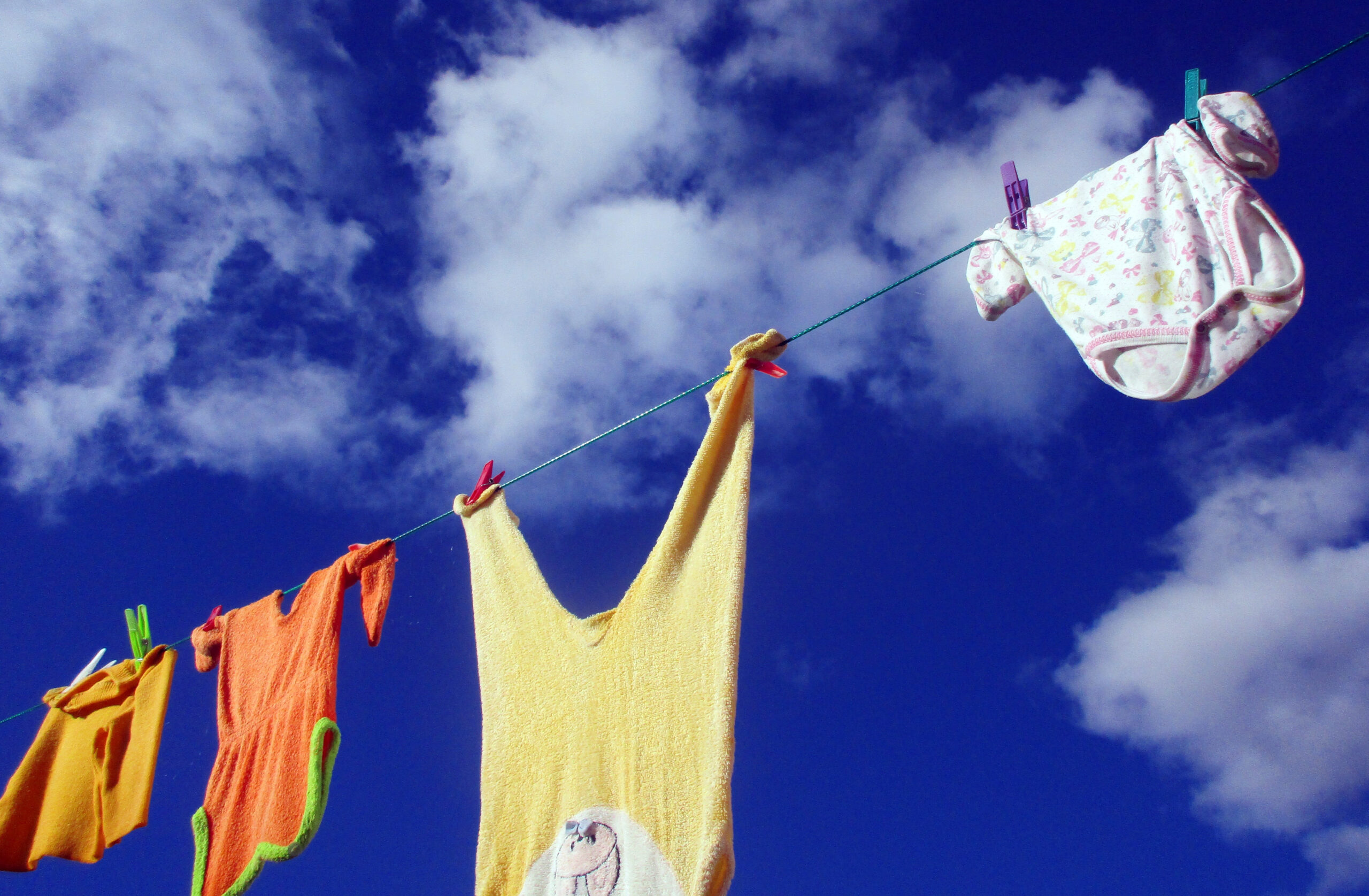 Washing hanging on a line backed by a blue, lightly clouded sky